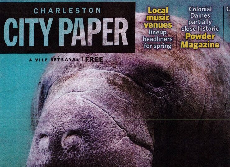 cover of a magazine with image of manatee under water